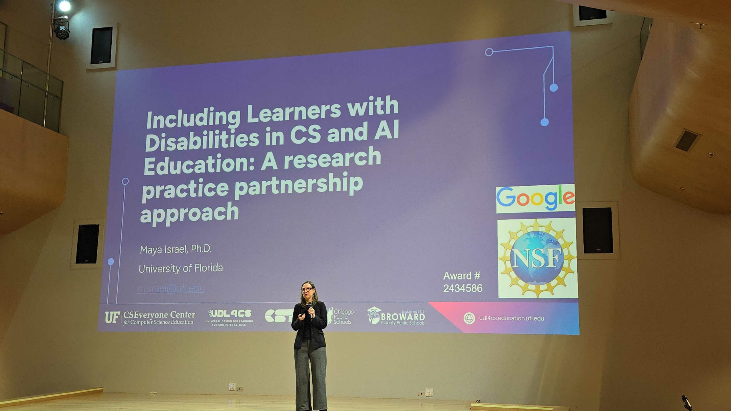 20251112_151346 Maya Israel presenting in front of a large screen at Asia Pacific Conference 2025.