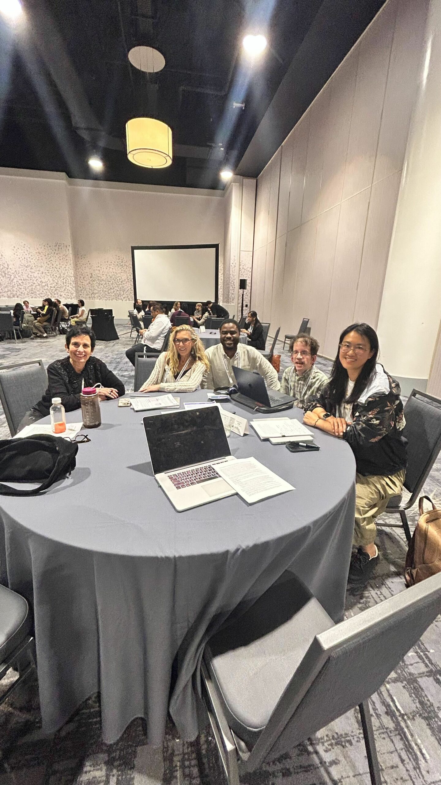 Meize Guo and Andrew Bennet sitting at table with other researchers.